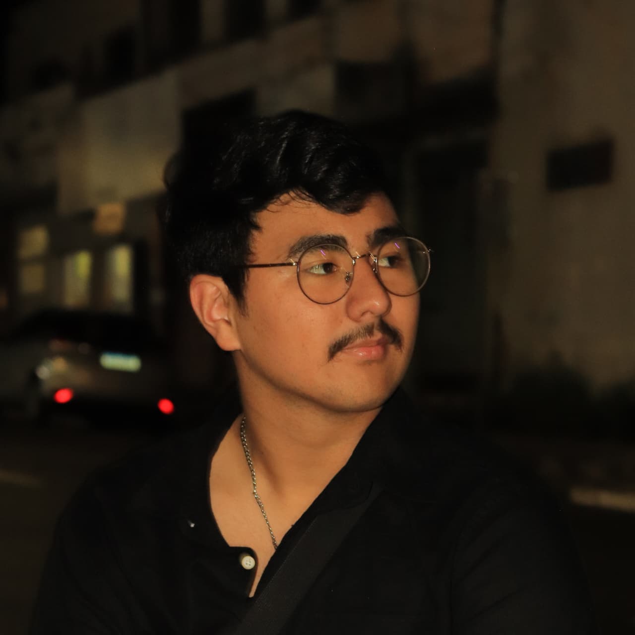 Foto de perfil de Arthur Shiroshima, a noite com uma rua ao fundo